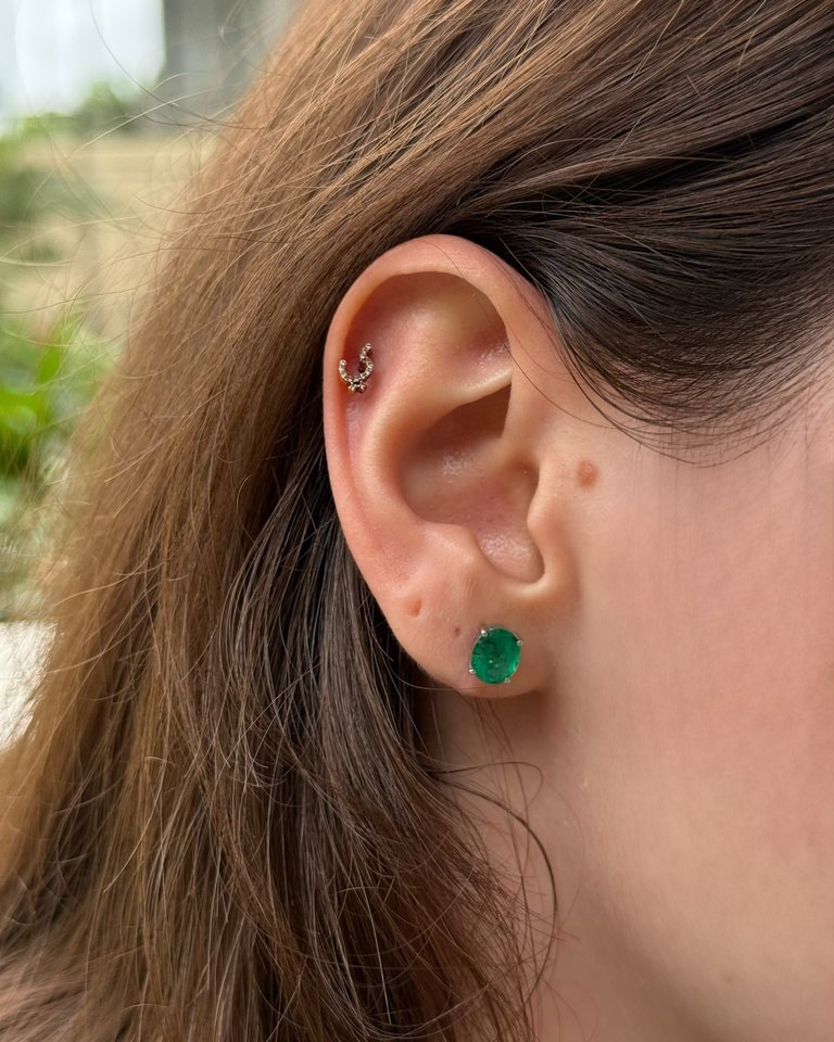 Gold emerald stud earring with a small horseshoe helix earring