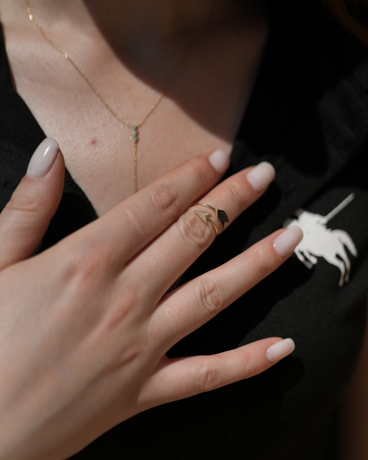 Gold open arrow ring with black and white stones