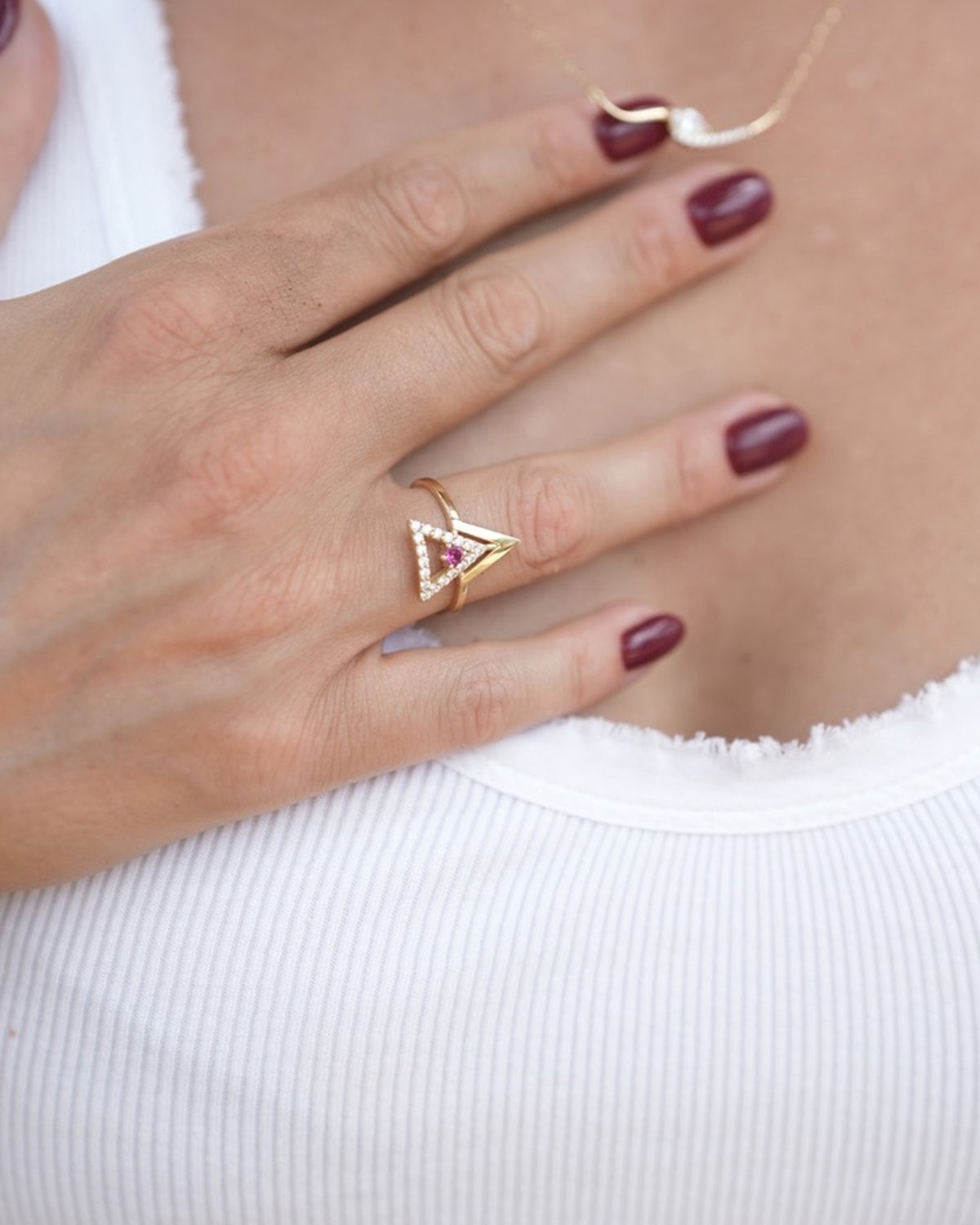 Gold arrow ring with a coloured centre stone