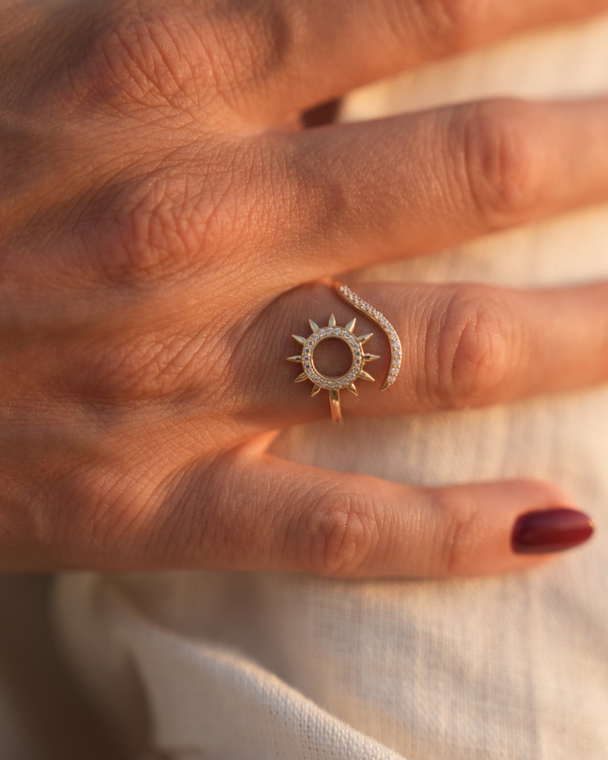 Gold sun ring set with white zircon, worn on the hand