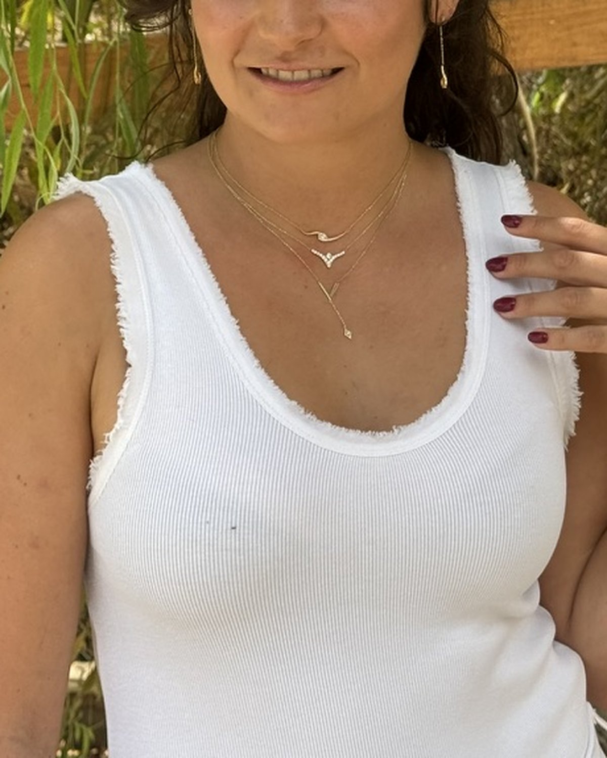 Gold V pendant necklace with a white stone drop, layered
